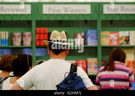 Hay Festival, Pays de Galles, Royaume-Uni - Mai 2016 - Un visiteur du Hay Festival parcourt l'énorme sélection de livres dans la librairie du Festival y compris le gagnant du prix de l'article. Banque D'Images