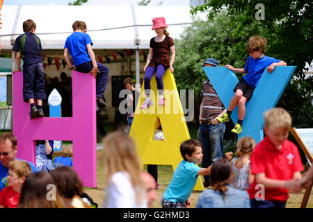 Hay Festival, Pays de Galles, Royaume-Uni - Mai 2016 - Les jeunes enfants profiter de la possibilité de jouer dans le foin géant des lettres sur les pelouses Hay Festival Banque D'Images