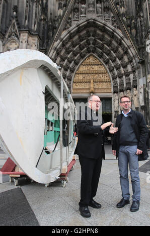 Cologne, Allemagne. 31 mai, 2016. Le doyen de la cathédrale de Cologne Gerd Bachner (l) et le maître constructeur de la Cathédrale Pierre Fuessenich debout à côté d'un sept mètres de long bateau de réfugiés en face de la cathédrale de Cologne à Cologne, Allemagne, 31 mai 2016. Le bateau de réfugiés a servi d'autel le jour de la fête du Corpus Christi. Entre 80 et 100 réfugiés utilisé le bateau un couple d'années plus tôt à fuir vers l'Europe depuis la Libye. PHOTO : OLIVER BERG/DPA/Alamy Live News Banque D'Images