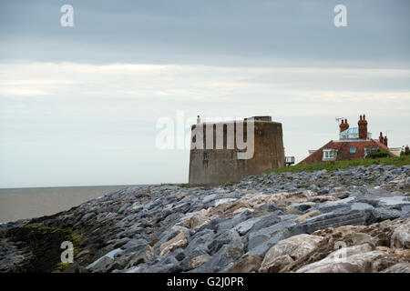 Rochers protégeant une tour Martello et les propriétés résidentielles de l'érosion côtière, à l'Est Lane, Bawdsey, Suffolk, UK. Banque D'Images