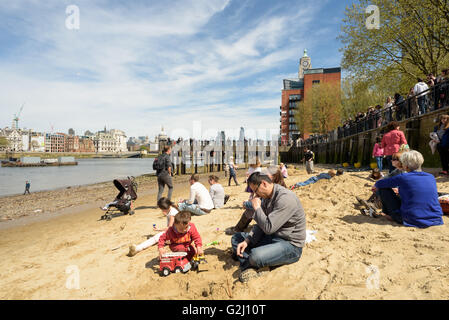 Séance familiale et reposant sur les rives sablonneuses de la Tamise à Londres à marée basse en mai 2016 sunshine Banque D'Images