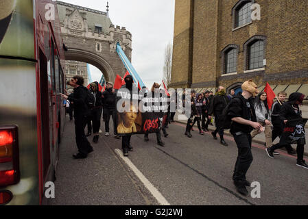 Groupe anarchiste du Premier Mai avec faces cachées, des slogans et des drapeaux rouges marchant sur le Tower Bridge 1er mai 2016 Banque D'Images