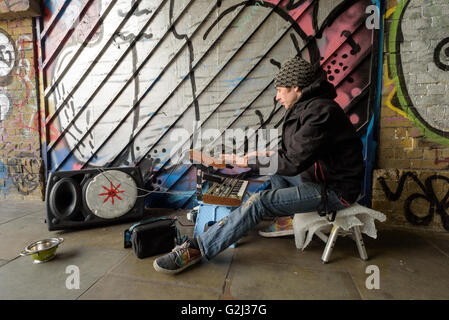 Busker électronique joue de la musique sur un système audio portable dans un tunnel sur Wheler Street à Londres Shoreditch, E1, Angleterre Banque D'Images