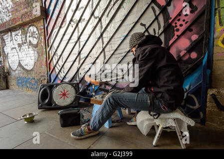 Busker électronique joue de la musique sur un système audio portable dans un tunnel sur Wheler Street à Londres Shoreditch, E1, Angleterre Banque D'Images