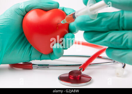 L'injection de cœur rouge sang avec des gants et un vert stéthoscope rouge sur fond blanc Banque D'Images