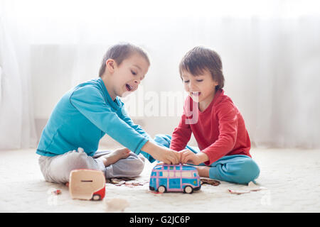 Petits enfants, garçons, brisant leur tirelire, vidant tous les économisé de l'argent pour acheter des cadeaux pour la fête des mères Banque D'Images