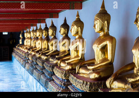 Statues en or doré de Bouddha assis dans un temple, le Wat Pho, Bangkok Banque D'Images