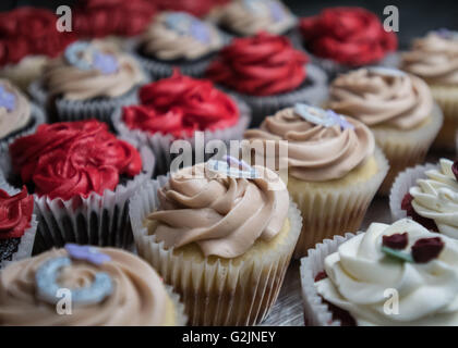 Rangées de Cupcakes décorées dans des tons rouges, blancs et bruns Banque D'Images