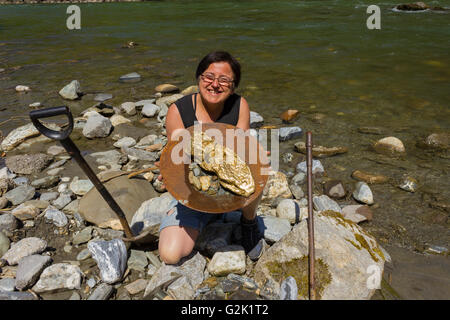 Femme l'occasion de chercher de l'or alluvial, en utilisant la méthode de déplacement traditionnel Banque D'Images