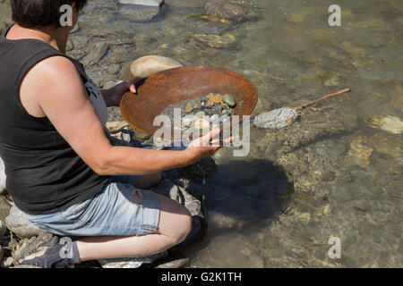 Femme l'occasion de chercher de l'or alluvial, en utilisant la méthode de déplacement traditionnel Banque D'Images