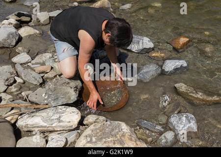 Femme l'occasion de chercher de l'or alluvial, en utilisant la méthode de déplacement traditionnel Banque D'Images