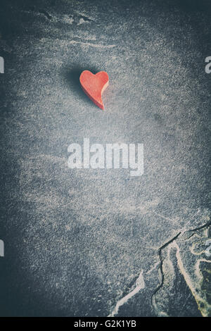 En bois aux tons Vintage grunge cœur rouge sur fond de pierre, profondeur de champ, l'espace pour le texte. Banque D'Images