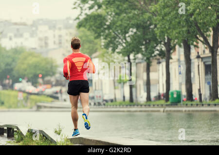 Jeune homme en train de courir dans la ville. Portrait souriant jogger homme dans son 20s Banque D'Images