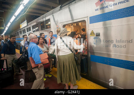 Des milliers pack la Cannonball à Penn Station à New York, pour sortir de la ville pour le week-end du Memorial Day, le vendredi 27 mai, 2016. Chaque vendredi durant l'été, le train, composé de wagons à impériale tiré par une puissante locomotive bi-mode, se déroulera express à Westhampton sur Long Island rendant le 76 kilomètres en 94 minutes. De Westhampton il continuera de points à l'est d'arriver à la pointe de l'île, Montauk. Le dimanche, le train s'inverse et retour à la gare Penn Station. Le train est le seul intitulé run sur le chemin de fer. Le voyage de Penn Station à la borne est 117 Montauk Banque D'Images