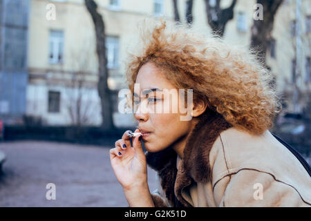 Jeune jolie fille à l'extérieur d'adolescent cigarette, ressemblant à du vrai junky, questions sociales concept Banque D'Images