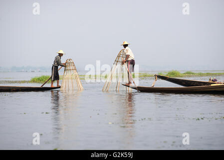 Deux pêcheurs ethnie Intha sur bois bateaux avec des filets de pêche traditionnels conic, lac Inle, l'État de Shan, myanmar Banque D'Images