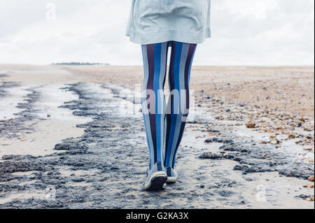 Les jambes d'une jeune femme qu'elle est la marche sur la plage Banque D'Images