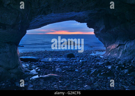 Coucher du soleil sur le golfe Saint-Laurent sculpté en calcaire antique vagues déferlantes éons Arches Provincial Park Terre-Neuve et Labrador Canada Banque D'Images