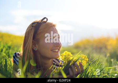 Portrait de belle jeune femme aux cheveux long couché dans park et Banque D'Images