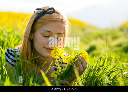 Portrait de belle jeune femme aux cheveux long couché dans park et fleurs odorantes Banque D'Images