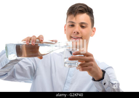 Adolescent waiter pouring water de bouteille en verre dans un verre isolé sur fond blanc Banque D'Images