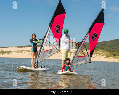 Famille sur des planches à voile. La plage de Valdevaqueros, Tarifa, Costa de la Luz, Andalousie, espagne. Banque D'Images