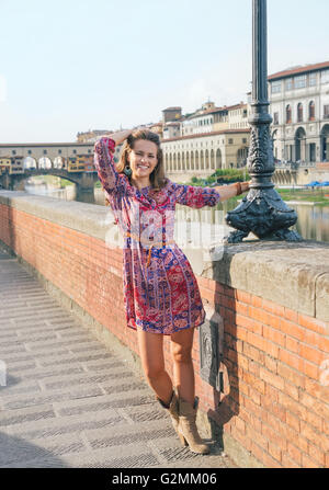 Maison de vacances remarquable à Florence. Portrait de femme heureuse dans une robe à marcher le long du talus, près de Ponte Vecchio Banque D'Images