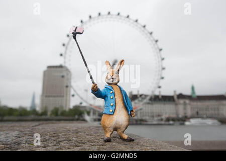 EDITORIAL n'utilisent qu'une sculpture miniature de Beatrix Potter Peter Rabbit prenant un caractère près du selfies London Eye à Londres, qui a été mise à jour pour le 21e siècle par l'artiste de rue Marcus Crocker dans la célébration du 150e anniversaire de la naissance de l'auteur. Banque D'Images