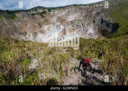 Un journaliste marche sur le bord du cratère du volcan du mont Mahawu à Tomohon, au nord de Sulawesi, en Indonésie. Banque D'Images
