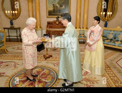 La reine Elizabeth II avec l'Ambassadeur de la République de Corée, M. Hwang, Joonkook qu'il présente ses lettres de créance au cours d'une audience privée a également assisté par son épouse, Mme Shil Rhee, au palais de Buckingham à Londres. Banque D'Images