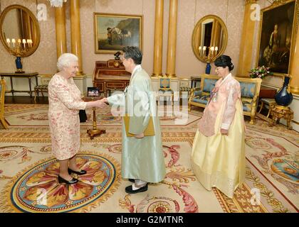 La reine Elizabeth II, serre la main avec l'Ambassadeur de la République de Corée, M. Hwang, Joonkook qu'il présente ses lettres de créance au cours d'une audience privée a également assisté par son épouse, Mme Shil Rhee, au palais de Buckingham à Londres. Banque D'Images