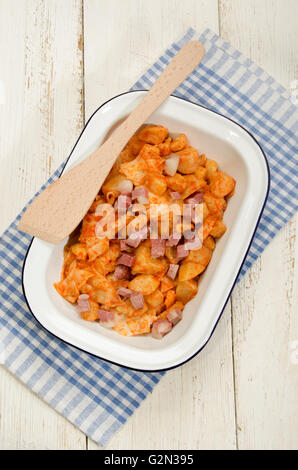 Repas traditionnels hongrois et de pommes de terre pâtes avec du paprika et bacon en émail bol et spatule en bois Banque D'Images