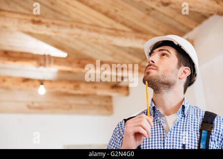 Close-up portrait of a smiling builder qui examine son lieu de travail Banque D'Images