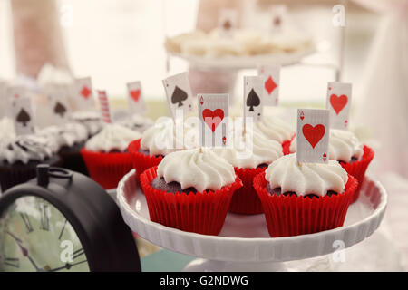 Red Velvet cupcakes avec cartes à jouer toppers, Alice au pays des merveilles tea party, tonification Banque D'Images