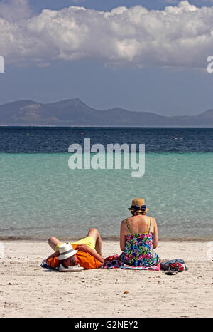 Couple d'âge moyen s'est assis sur la plage à Alcudia, Majorque Banque D'Images