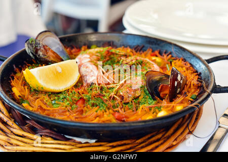 Libre d'une fideua typique espagnol, une casserole de nouilles aux fruits de mer, paella dans un moule sur une table de jeu Banque D'Images
