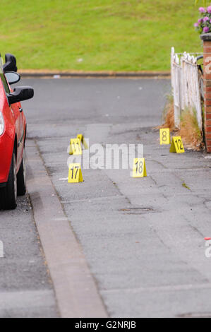 Belfast, 06/06/2012 - Des marqueurs numérotés sont utilisés pour identifier les preuves par scène de crime du Bureau qu'ils effectuent une enquête médico-légale sur un sentier pavé rue. Banque D'Images