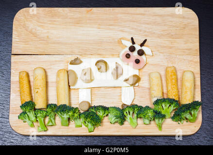 Paysage avec vaches fabriqué à partir de fromage blanc, carottes, brocoli, champignons et jambon, concept artistique Banque D'Images