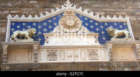 Détail de l'entrée avant le Palazzo Vecchio. Hôtel de ville de Florence, en Italie. Un immense palais-forteresse romane donnant sur la Piazza della Signoria. L'entrée présente une plante ornementale en frontispice, datant de 1528. Le monogramme du Christ se trouve au milieu, flanqué de deux lions dorés, avec le texte latin : 'Rex Regum et Dominus Dominantium". Ce qui peut être traduit comme : "par Jésus Christ, Roi des Rois et Seigneur des Seigneurs". Ce texte date de 1851. Banque D'Images