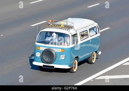 Vue latérale et avant de l'antenne, vue vers le bas sur le modèle VW classique Volkswagen Camper van conduite le long de l'autoroute anglaise du Royaume-Uni nombre masqué plaque Banque D'Images