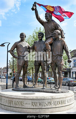 Joueurs de football de la Coupe du Monde de la sculpture avec Bobby Moore & World Cup trophy plus fans West Ham fixe bannière à la tasse sur Barking Road Upton Park London UK Banque D'Images