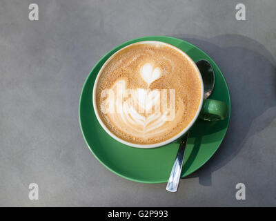 Tasse et soucoupe, cuillère, café latte avec motif coeur sur la surface Banque D'Images