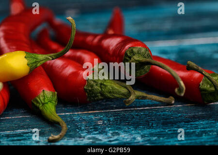 Piment rouge et jaune bleu sur fond de bois Banque D'Images