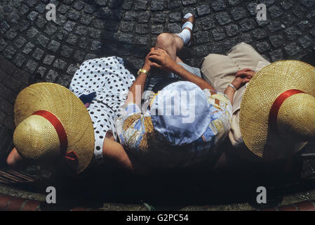 Un groupe mature assis de trois personnes portant des chapeaux de soleil en vacances, Great Yarmouth, Norfolk, Angleterre. ROYAUME-UNI. Europe Banque D'Images