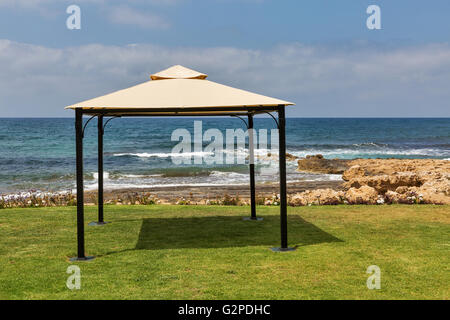 Petit pavillon sur l'herbe verte pelouse de rocky mer plage Banque D'Images
