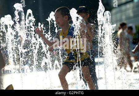 Liuzhou, Chine, région autonome Zhuang du Guangxi. 1er juin 2016. Un jeune garçon cools off en fontaines à Liuzhou City, en Chine, région autonome Zhuang du Guangxi, 1 juin 2016. Une vague chaude affecté la région au cours des derniers jours, avec la température la plus élevée atteignant 37 degrés Celsius. Crédit : Li Hanchi/Xinhua/Alamy Live News Banque D'Images