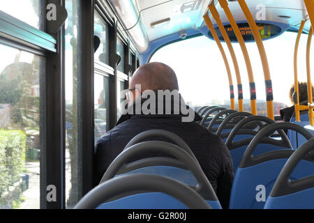 Homme chauve portant des lunettes noires, veste de fenêtre donne sur plateau supérieur du bus de Londres Banque D'Images