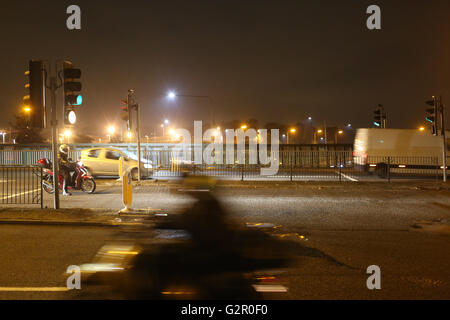 La nuit, les voitures, les motos et d'un van aux feux de circulation sur un pont au-dessus de la A406 North Circular ring road. Banque D'Images