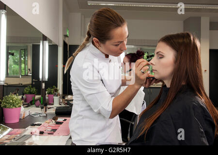 Maquillage coiffeur une jeune femme. Banque D'Images