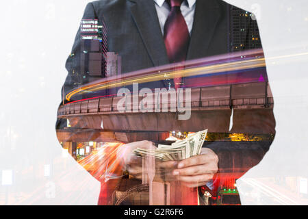 Double exposition de l'homme d'affaires en fonction de l'argent comptant et gratte-ciel urbain Banque D'Images